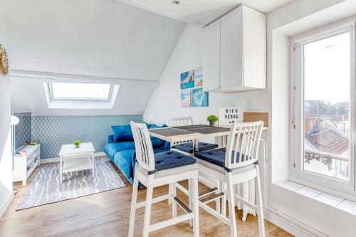 un salon avec un canapé bleu, une table et des chaises dans l'établissement Escale pro & détente à 3 min de la gare - Parking - WIFI - PS4, à Corbeil-Essonnes