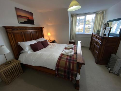 1 dormitorio con 1 cama grande y vestidor en Beach View Cottage, en Isle of Gigha