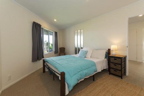 een slaapkamer met een groot bed en een raam bij Doubtless Bay Retreat 