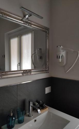 a bathroom with a sink and a large mirror at Le Farfalle di Armeno in Armeno