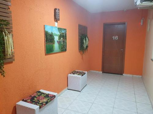 a hallway with an orange wall with a door and a door sidx sidx at Pousada Recanto do Sal in Salinópolis