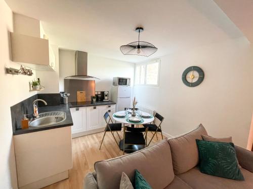une cuisine et un salon avec un canapé et une table dans l'établissement Duplex au pied de la gare - NETFLIX - Hyper-centre, à Amiens