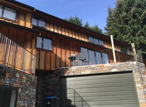 a dog is looking out of the balcony of a house at Alpine Retreat in Queenstown