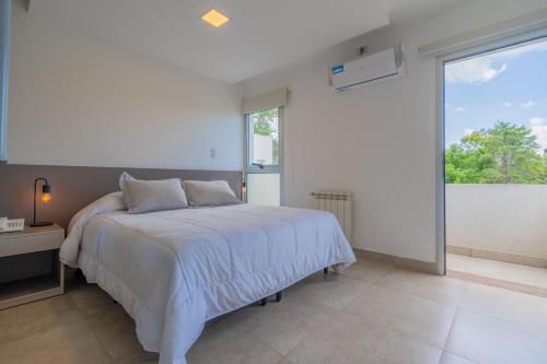 圣洛伦索SIETE LUNAS DE San Lorenzo的卧室里有一张白色的床和一扇大窗户