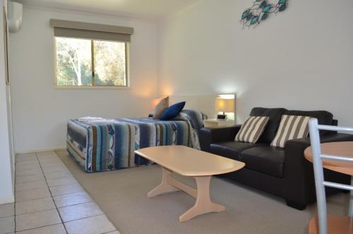 a living room with a couch and a table at Yamba Motor Inn in Yamba