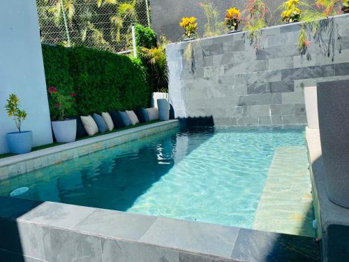 a swimming pool with a stone retaining wall and a swimming pool at Las Naveiras in Tamarindo