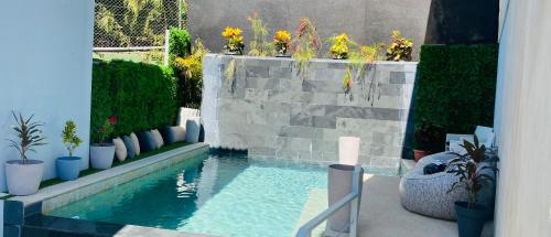 a swimming pool in a garden with plants and flowers at Las Naveiras in Tamarindo
