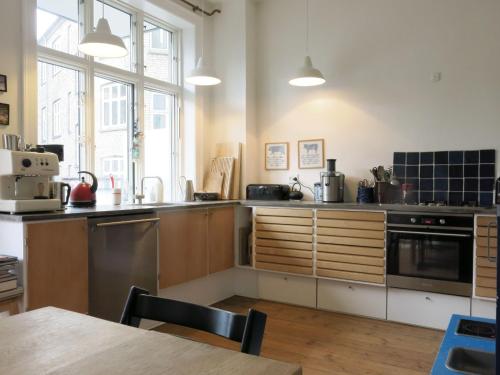 uma cozinha com utensílios de aço inoxidável e uma mesa em ApartmentInCopenhagen Apartment 1282 em Copenhague