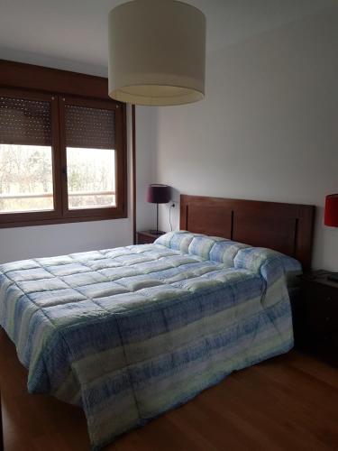 a bedroom with a bed with a blue blanket on it at Apartamento La Esperanza in Cangas de Onís