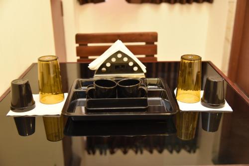 una mesa con una bandeja con dos vasos. en Sree Ganesh Inn, en Palani