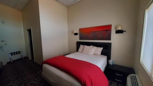a bedroom with a bed with a red blanket at Lowell Inn in Stillwater