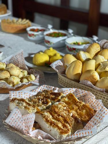 a table topped with plates of food and baskets of bread at Ronco do Mar Cumbuco in Cumbuco