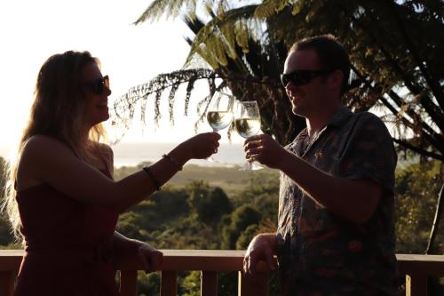 a man and woman holding glasses of white wine at Treescapes - Rainforest Hot Tub 2km from Punakaiki in Punakaiki