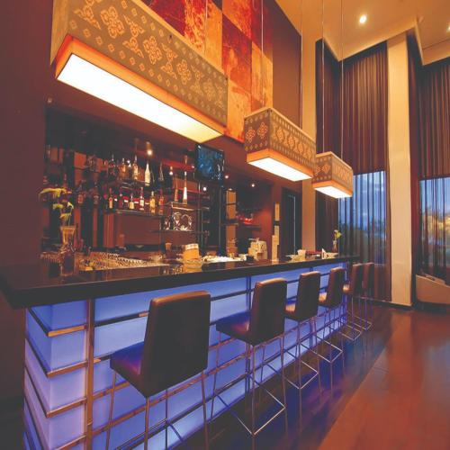 a bar with a row of chairs in a restaurant at Swiss-Belhotel Ambon in Ambon