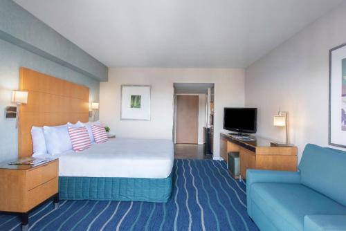 a hotel room with a large bed and a couch at Ala Moana Honolulu by Mantra in Honolulu