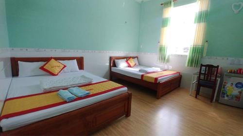 a bedroom with two beds and a window at Ngôi Sao Homestay in Vĩnh Hy