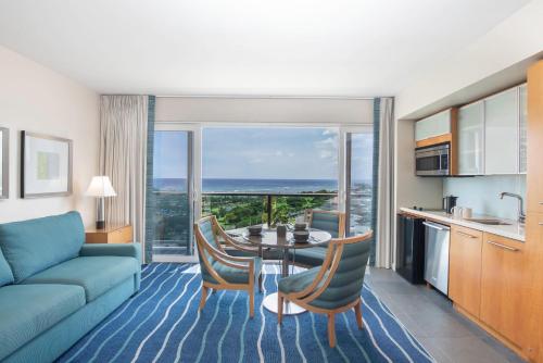 a living room filled with furniture and a large window at Ala Moana Hotel - Resort Fee Included in Honolulu