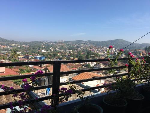a view of a city from a balcony with flowers at Coorg North Breeze Homestay in Madikeri