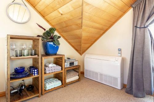 a attic room with a vaulted ceiling and a heater at Riverside Retreat in Queenstown