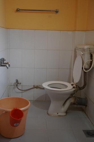 a bathroom with a toilet and a bucket at Hotel Rajesh in Kolhapur