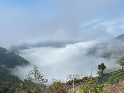 a view of a foggy valley in the mountains at Tianen Farm in Hualing