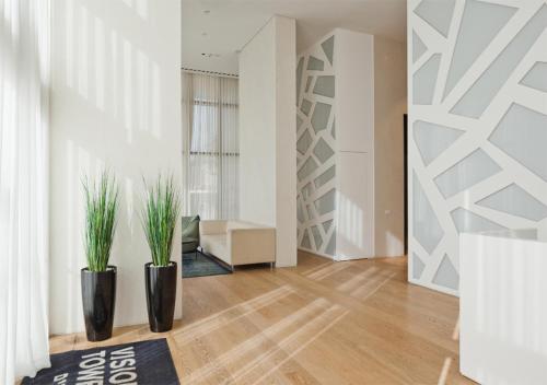 a living room with two potted plants on the floor at Oַ&O Group- Luxury Penthouse Jacuzzi Sea 36 Floor in Bat Yam