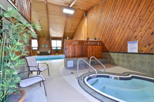 a swimming pool with a jacuzzi tub in a building at Super 8 by Wyndham Deadwood Black Hills Area in Deadwood