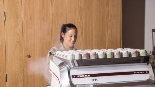 a woman is standing next to a batch of cupcakes at Hotel Indigo Adelaide Markets by IHG in Adelaide