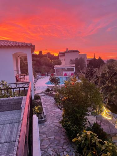 a sunset over a villa with a stone walkway at Maxima Sunset in Sainte-Maxime