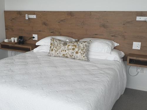 モッセル・ベイにあるVilla Vistaの白い枕が付いた大きなベッドのある寝室