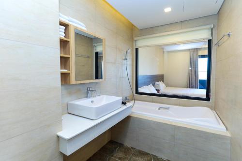 クイニョンにあるFLC Sea Tower Quy Nhon - Seaview Apartelの洗面台、浴槽、鏡のあるバスルーム