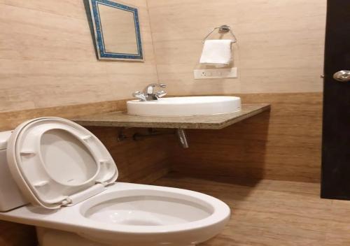 a bathroom with a white toilet and a sink at Areia De Goa - Sunrise By Leela Homes in Arpora