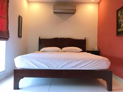 a bedroom with a large bed with white sheets at Morgah Resort - Guest Rooms in Rawalpindi