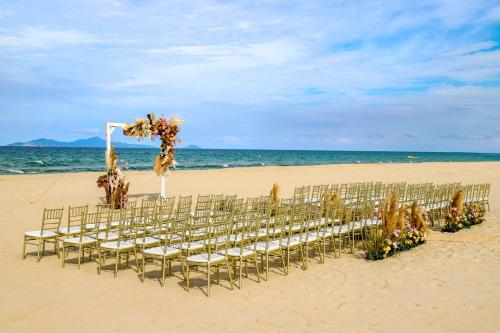 a beach with a bunch of chairs on the beach at Naman Retreat in Da Nang