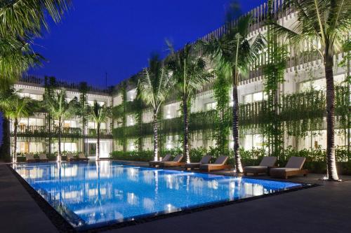 a hotel with palm trees and a swimming pool at Naman Retreat in Da Nang
