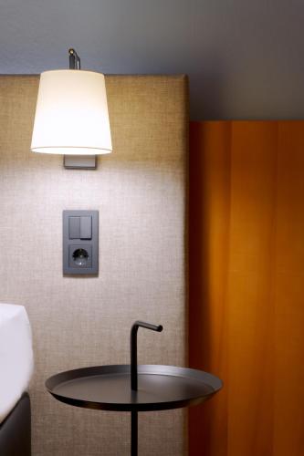 a table in a room with a lamp at Hotel am Kloster in Werne an der Lippe