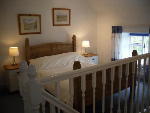 a bedroom with a bed and two lamps and a staircase at Cottage with amazing views of the North York Moors in York