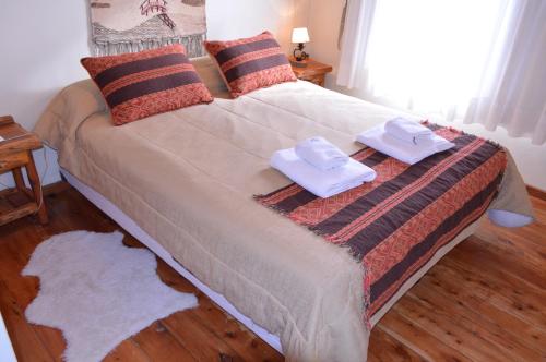 ein Schlafzimmer mit einem Bett mit zwei Handtüchern darauf in der Unterkunft Hostería Traunco in Villa La Angostura