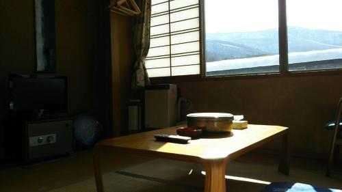 a table with a bowl on top of it next to a window at 伊藤屋 in Zao Onsen