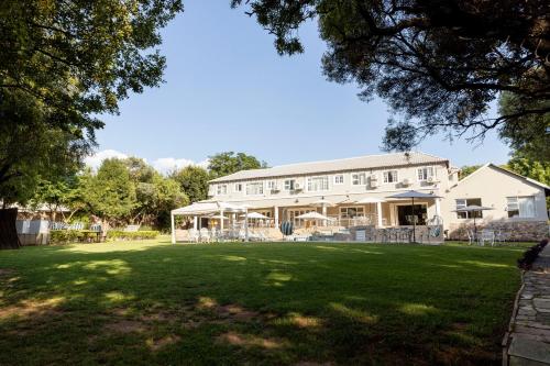 a large white house with a large yard at Dikalo Highston Boutique Guest house in Bryanston Sandton Johannesburg in Johannesburg