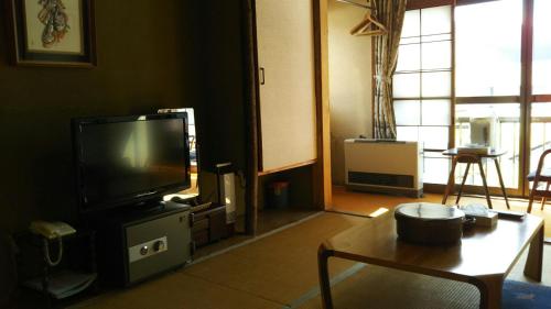 a living room filled with furniture and a tv at 伊藤屋 in Zao Onsen