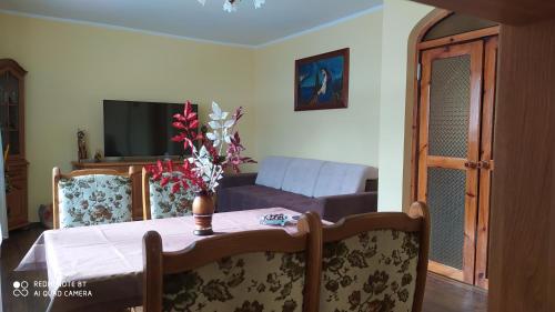 a living room with a table with a vase of flowers on it at Agroturystyka Swojska Chata in Mrągowo