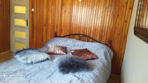 a bed with some pillows on top of it at Agroturystyka Swojska Chata in Mrągowo