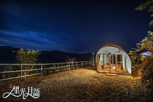 a small greenhouse in a field at night at 清境花鳥蟲鳴高山露營區 in Jen-chuang
