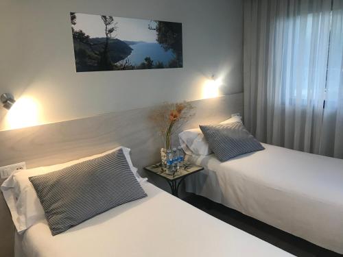 1 dormitorio con 2 camas y mesa auxiliar en Hotel Kanala, en Deba