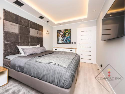 Un dormitorio con una cama grande y una pared en COMFORT INN APARTMENTS - Gdansk, Sadowa en Gdansk