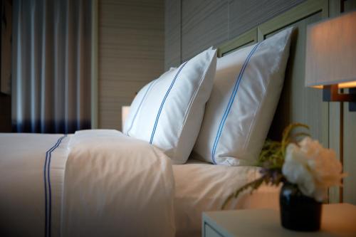 a bedroom with a bed with white sheets and pillows at Signiel Busan in Busan