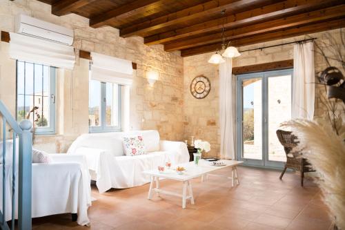 a living room with a white couch and a table at Beachfront villa Turquoise with private pool, BBQ and ping pong table in Chania Town