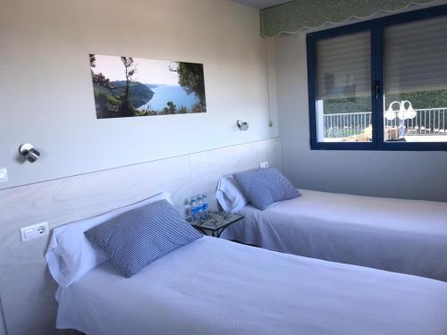 a hotel room with two beds and a window at Hotel Kanala in Deba