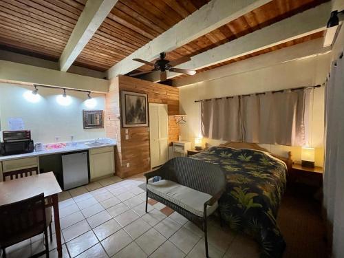 Cet appartement comprend une chambre avec un lit et une table ainsi qu'une cuisine. dans l'établissement Coffee Garden, à Captain Cook